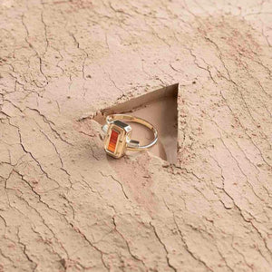 Introducing the Achates Collection: a 14K solid gold ring featuring a rectangular natural carnelian gemstone at its center, elegantly accented with small clear gemstones on each side. The band offers a simple yet sophisticated design.