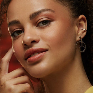 Crafted from 14K real solid gold, the earrings from the Harmony Collection feature a design with two concentric circles connected by a delicate chain. The larger circle gracefully hangs from the earlobe, with the smaller below it, offering a modern and elegant look that is both stylish and hypoallergenic.