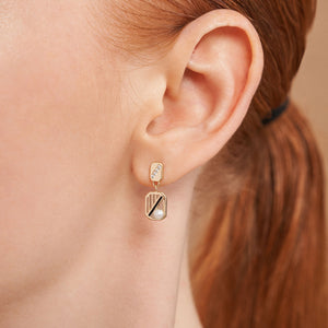 The 14K Real Gold Valor Natural Pearl Earrings from the Elegance Collection feature geometric rectangular frames with a genuine pearl at the bottom and a diagonal black stripe. The top is adorned with small diamonds set on a rectangular base, making them hypoallergenic and ideal for sensitive ears.