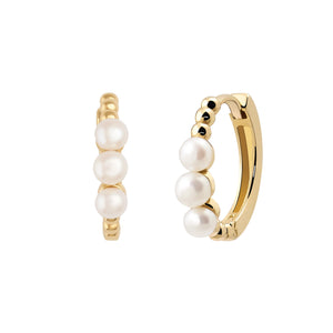 Introducing the 14K Solid Gold Natural Pearl Simplicity Hoop Earrings from the Elegance Collection. This pair of small hoop earrings, crafted with sustainable methods, features three evenly spaced white pearls on each earring. With a shiny finish and hypoallergenic properties, they offer a simple yet elegant design, beautifully displayed on a white background.