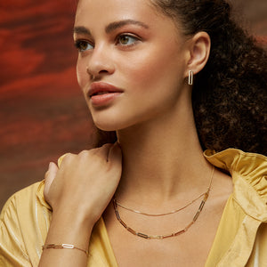 The 14K Solid Gold Double Layer Paperclip Necklace from the Harmony Collection features a contemporary and minimalist style with two layers: one with a delicate chain and the other with elongated rectangular links. Hypoallergenic and offered in various chain sizes, it epitomizes elegance and versatility.