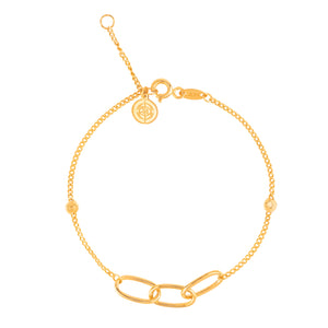 The 14K Solid Gold Triple Interlocking Unity Bracelet from the Harmony Collection boasts three prominent interlocking links at the center, accompanied by small circular charms and an adjustable clasp. Model No X5B201376 is distinguished by its intricate chain and charm detailing, featuring a hypoallergenic design ideal for those with sensitive skin.