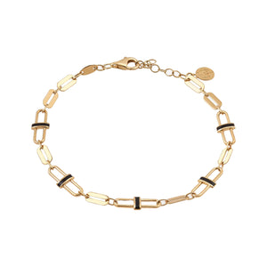 A 14K solid gold paperclip chain bracelet with black enamel accents, showcasing a lobster clasp and featuring a small round moon eclipse charm near the clasp from the Moonlight Collection.