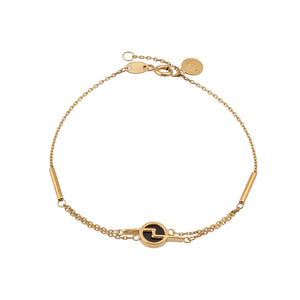 The 14K Solid Gold Black Enamel The Black Rotation Chain Bracelet from the Moonlight Collection is a delicate hypoallergenic gold chain bracelet featuring a circular black and gold pendant at its center. Crafted from 14K solid gold, it includes an adjustable clasp complemented by small circular tags near the closure. Model No B22DK0289-1-CZ adds a touch of elegance to any outfit.