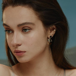 The 14K Solid Gold Elegant Dangle Drop Earrings of the Moonlight Collection showcase a circular black enamel stone at the top and a split semicircular design below, linked together to form a graceful drop. Their glossy finish and post backings enhance the elegance of these hypoallergenic accessories.