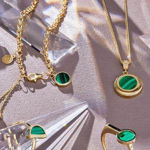 Introducing the 14K Solid Gold Diamond & Malachite Pendant Necklace from our Endless Collection, featuring a circular pendant with a natural malachite gemstone surrounded by small gold beads. This exquisite pendant, crafted from 14K real solid yellow gold, is delicately attached to a fine gold chain and adorned with sparkling crystal accents above.