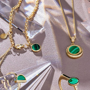 The 14K Solid Gold Rolo Chain Malachite Drop Chain Bracelet from the Endless Collection is an elegant piece featuring a delicate chain adorned with two small dangling spheres and a round, green-striped malachite gemstone charm. It includes a hypoallergenic lobster clasp and a small circular tag for added sophistication.