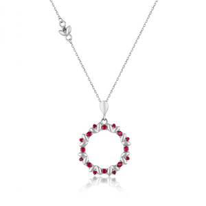 The Flower Ledder Ruby Pendant Necklace from the Chloris Collection showcases a circular pendant embellished with small lab-grown ruby accents and a delicate bow, intricately crafted from hypoallergenic 14K solid gold.