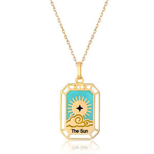 The Sun - 14K Solid Gold Tarot Necklace from the Tarot Collection highlights a tarot card design of The Sun, featuring a stylized sun with rays and clouds set against a turquoise backdrop. This hypoallergenic pendant elegantly hangs from a delicate gold chain.