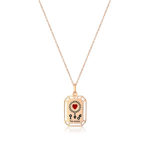 This stunning 14K solid gold necklace from the Tarot Collection, known as "The Lovers," showcases a beautifully detailed tarot pendant. It features a stylized heart with radiant rays at the center, accompanied by a key and keyhole design. Below, the phrase "The Lovers" is elegantly inscribed. The pendant hangs gracefully from a hypoallergenic, delicate chain.