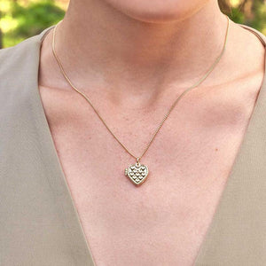 The 14K Solid Gold Heart Shaped Custom Photo Locket Medallion Necklace from the Timeless Collection is crafted from genuine solid yellow gold and features a quilted texture with a delicate rope border. This hypoallergenic piece hangs elegantly from a sleek chain and is beautifully displayed against a plain white background.