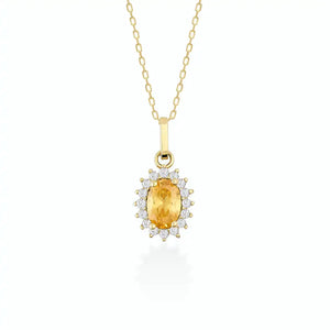 The 14K Gold Oval Citrine Necklace by RundaJewelryUs showcases a pendant with a prominent oval-shaped yellow citrine, encircled by a halo of shimmering white gemstones, elegantly displayed against a simple backdrop.