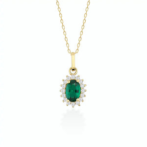 The 14K Gold Oval Emerald Necklace showcases a delicate oval pendant adorned with a prominent green emerald, surrounded by sparkling zirconia stones, making it an ideal choice for women who value elegance.