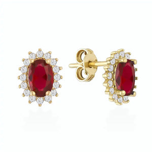 Introducing the 14K Gold Oval Shaped Ruby Stud Earrings, featuring stunning red gemstones encased in 14K gold and surrounded by a halo of sparkling white diamonds, perfect for adding a touch of elegance.