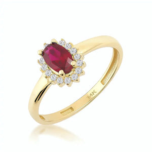 The 14K Solid Gold Ruby July Birthstone Ring features an oval red gemstone encircled by a halo of small, round diamonds. The band is sleek, polished, and stamped with the 14K mark on the inside. Each ring is part of our exclusive handmade jewelry collection and is presented against a plain white background.