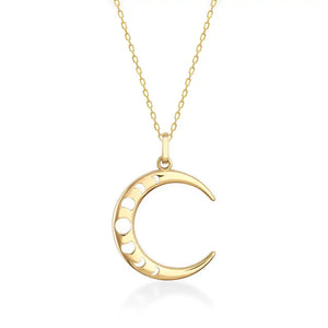 The 14K Real Gold Crescent Moon Phases Necklace showcases a crescent moon pendant embellished with subtle circular cutouts and shimmering cubic zirconia gemstones. Its delicate chain and the polished finish of the pendant contribute to its elegant appearance.