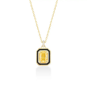 The 14K Gold Citrine Necklace showcases a rectangular yellow gemstone pendant, elegantly framed in black and adorned with small white stones. Its delicate chain enhances the vibrant centerpiece perfectly.