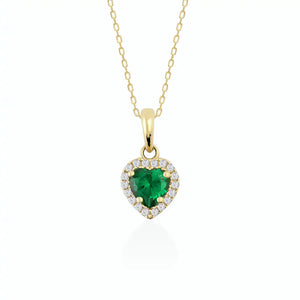 The 14K Gold Heart Emerald Necklace showcases a green, heart-shaped zirconia emerald pendant elegantly surrounded by small, sparkling diamonds, forming a delicate and luxurious necklace for women.