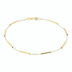 Introducing the 14K Gold Minimal Station Bracelet by RundaJewelryUs: a delicate design featuring a thin chain accented with small, evenly spaced tube-shaped beads in lustrous 14K gold. This elegant piece is securely fastened with a traditional lobster claw closure.