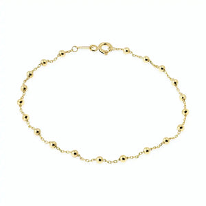 The 14K Solid Gold Bead Station Bracelet is a delicate piece, showcasing small round beads evenly spaced along its thin real solid gold chain. Set against a white background, this stunning bracelet is finished with a lobster clasp closure that ensures elegance and security.