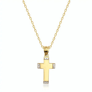 This minimalist jewelry piece is the 14K Gold Tiny Cross Necklace by RundaJewelryUs, featuring a chain with diamond-like stones embellishing the top and bottom edges of the cross. It's a timeless religious accessory elegantly showcased against a plain white background.