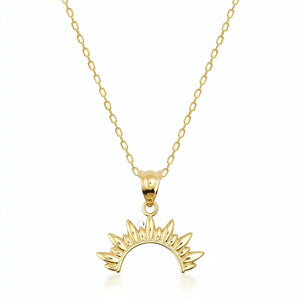 The 14K Gold Rising Sun Necklace showcases a delicate chain adorned with a sunburst pendant. This semi-circular pendant, featuring pointed rays, radiates celestial charm. Elegantly handcrafted from fine gold, the piece is beautifully presented on a plain white background.