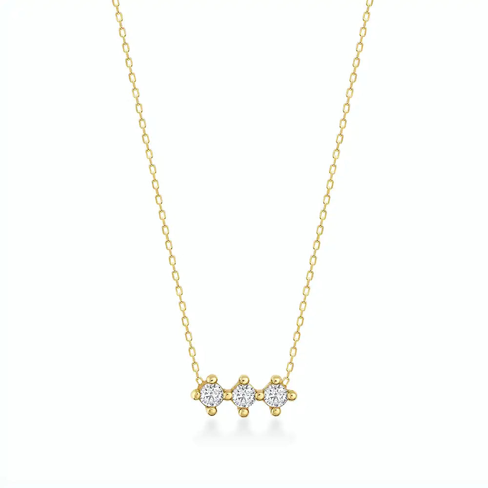 The 14K Gold Trio Necklace is a delicate piece with three small, round diamond stones set in a row on a thin, hypoallergenic gold chain against a light background.