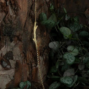 The 14K Solid Gold Tree Branch Bracelet from the Into the Woods Collection by Erdem Akan showcases a textured twig-like centerpiece available in yellow, white, or rose gold. Its hypoallergenic design is elegantly attached to a delicate chain with a secure clasp closure.