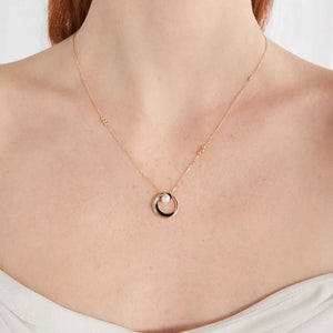 The necklace from the Elegance Collection is made of 14K solid yellow gold and features a circular pendant with a black accent and a natural pearl at its center. The hypoallergenic chain is delicate and enhances the elegant design of the pendant.