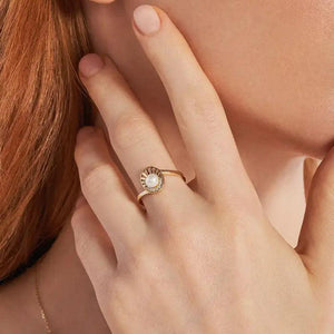 The 14K Solid Gold Natural Pearl Ring from the Elegance Collection features an artistic swirl design, highlighting a natural pearl and adorned with sparkling diamonds. Crafted in 14K solid gold, this ring exemplifies elegance through sustainable methods.