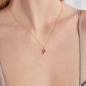 Introducing the 14K Solid Gold Natural Pearl Necklace from the Elegance Collection, featuring a delicate 14K solid yellow gold chain. This exquisite piece showcases a pendant with a polished gold sphere and natural pearl, separated by a textured gold ring. The hypoallergenic design offers both elegance and minimalism.