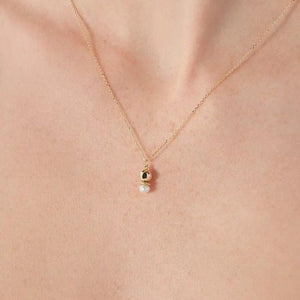 Introducing the 14K Solid Gold Natural Pearl Necklace from the Elegance Collection, featuring a delicate 14K solid yellow gold chain. This exquisite piece showcases a pendant with a polished gold sphere and natural pearl, separated by a textured gold ring. The hypoallergenic design offers both elegance and minimalism.