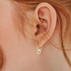 Presenting the stunning 14K Solid Gold Voyage Natural Pearl Dangle Earrings from the Elegance Collection. These earrings feature genuine pearls at the base and a row of tiny sparkling diamonds along the upper front. One earring is displayed front-facing, while the other is shown in profile against a plain white background.