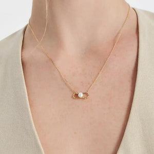 Part of the Elegance Collection, this 14K solid gold necklace features a unique pendant with a natural white pearl at its center, tastefully accented by two small round diamonds within an abstract geometric design.