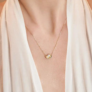 Introducing the Elegance Collection's 14K Solid Gold Natural Pearl Necklace, featuring a circular pendant showcasing a natural pearl at its center. The design includes two gold crescent shapes gently cradling the pearl, all beautifully crafted in 14K real solid yellow gold and suspended on a delicate hypoallergenic gold chain.