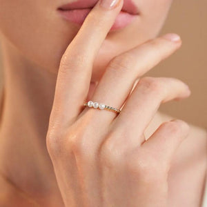 The 14K Solid Gold Bubble Natural Pearl Ring from the Elegance Collection features two rows of small, round beads topped with three larger, natural pearls. Its elegantly modern design showcases Runda's exquisite craftsmanship and is artfully displayed against a plain white background.