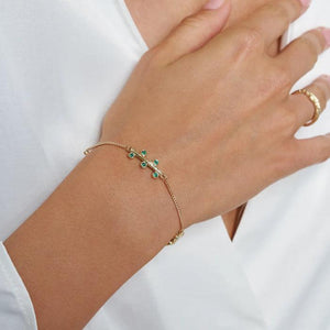 Experience the exquisite beauty of the 14K Solid Gold Blossom Bracelet from the Into the Woods Collection by Erdem Akan. This elegant piece features a delicate chain adorned with green gemstones and three horizontal bars, each embellished with vibrant stones. The fine gold chain includes a secure clasp and is hypoallergenic, available in yellow, white, or rose gold options.