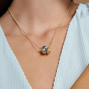 Introducing the 14K Solid Gold Acorn Necklace from the Into the Woods Collection by Erdem Akan. This exquisite piece features a pendant adorned with two clear, faceted stones, expertly crafted from genuine 14K solid yellow gold. The necklace showcases a textured design that resembles a cluster for an artistic touch and is hypoallergenic for comfortable wear. It's finished with a secure lobster claw clasp, all set against a plain white backdrop.