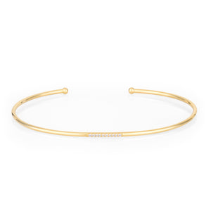 Introducing the 14K Solid Gold Diamond Seed of Colors Bracelet from the Chloris Collection, a beautifully simple and elegant open bangle crafted in solid gold. This bracelet features small, hypoallergenic lab-grown diamond accents at its center, with a sleek and minimalist design complemented by its rounded ends.