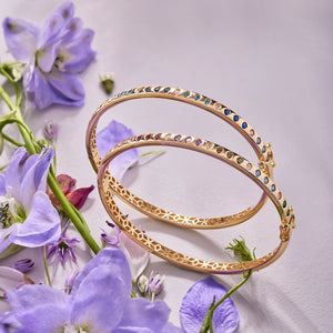 A 14K Solid Gold Diamond Earth Tones Bracelet from the Chloris Collection, featuring a geometric cutout pattern along the sides and adorned with a sequence of colorful lab-grown gemstones set around its outer edge.