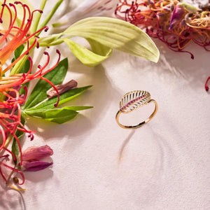 The 14K Solid Gold The Leaf Gold Ring from the Chloris Collection features a graceful leaf-like motif adorned with lab-grown rubies in the center. Its sleek band enhances the intricate detailing, crafted using sustainable methods.