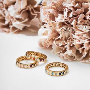 The 14K Solid Gold Diamond Earth Tones Ring from the Chloris Collection showcases lab-grown gemstones in a variety of red, orange, blue, and clear tones arranged in an alternating pattern. The inside surface is distinguished by a unique geometric cut-out design, making it both stylish and hypoallergenic for those with sensitive skin.