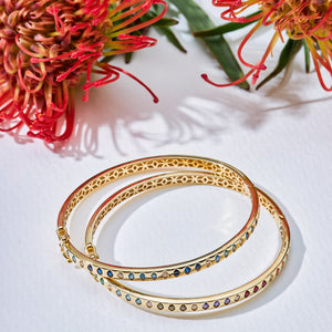 A 14K Solid Gold Diamond Earth Tones Bracelet from the Chloris Collection, featuring a geometric cutout pattern along the sides and adorned with a sequence of colorful lab-grown gemstones set around its outer edge.