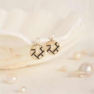 Part of the Elegance Collection, the 14K Solid Gold Asymmetry Natural Pearl Dangle Earrings offer a luxurious blend of modern design and classic style. These earrings feature geometric circular pendants crafted in 14K real solid gold, embellished with black accents and topped with genuine pearl studs. Hypoallergenic, they are perfect for those with sensitive ears.