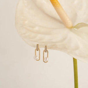 Introducing the 14K Solid Gold Inception Natural Pearl Stud Earrings from the Elegance Collection—an exquisite pair featuring vertical bars adorned with small gems, each showcasing a genuine pearl in a striking large tear-shaped design. These stunning earrings hang gracefully from oval loops and are crafted from 14K real solid gold, making them hypoallergenic and perfect for those with sensitive skin.