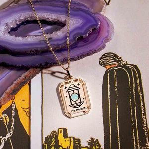 This 14K solid gold necklace from the Tarot Collection features a captivating lantern design on its hypoallergenic pendant, inscribed with "The Hermit" and adorned with intricate geometric cutouts along the border, making it ideal for those with sensitive skin.