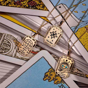 Discover "The Star" from our Tarot Collection, a 14K solid yellow gold necklace featuring a delicately crafted rectangular tarot pendant with a central star design surrounded by smaller stars. This hypoallergenic piece is elegantly engraved with "The Star" at the bottom and comes with a simple, delicate chain.