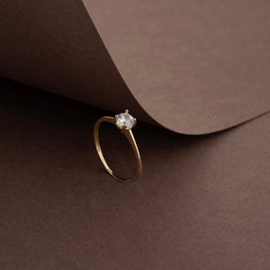 The 14K Solid Gold Zirconia Gemstone Solitaire Ring is artfully crafted with a single round-cut zirconia stone set in a classic prong setting, elegantly showcased against a white background.