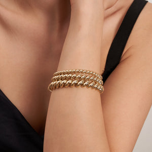 This 14K Real Solid Gold San Marco Bracelet showcases a circular design with a twisted pattern, featuring rounded, shiny links arranged in an elegant spiral. It is displayed against a plain white background.