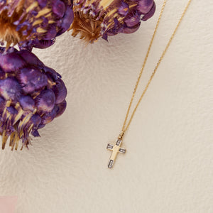 The 14K Solid Gold Tiny Minimal Cross Necklace, featuring a gold chain and a cross pendant embellished with small white gemstones, exudes elegance. The simple white background highlights its delicate design, making it a perfect piece of religious jewelry or a meaningful Christian faith gift.